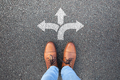 Feet on black top with white arrows pointing left, right and straight ahead