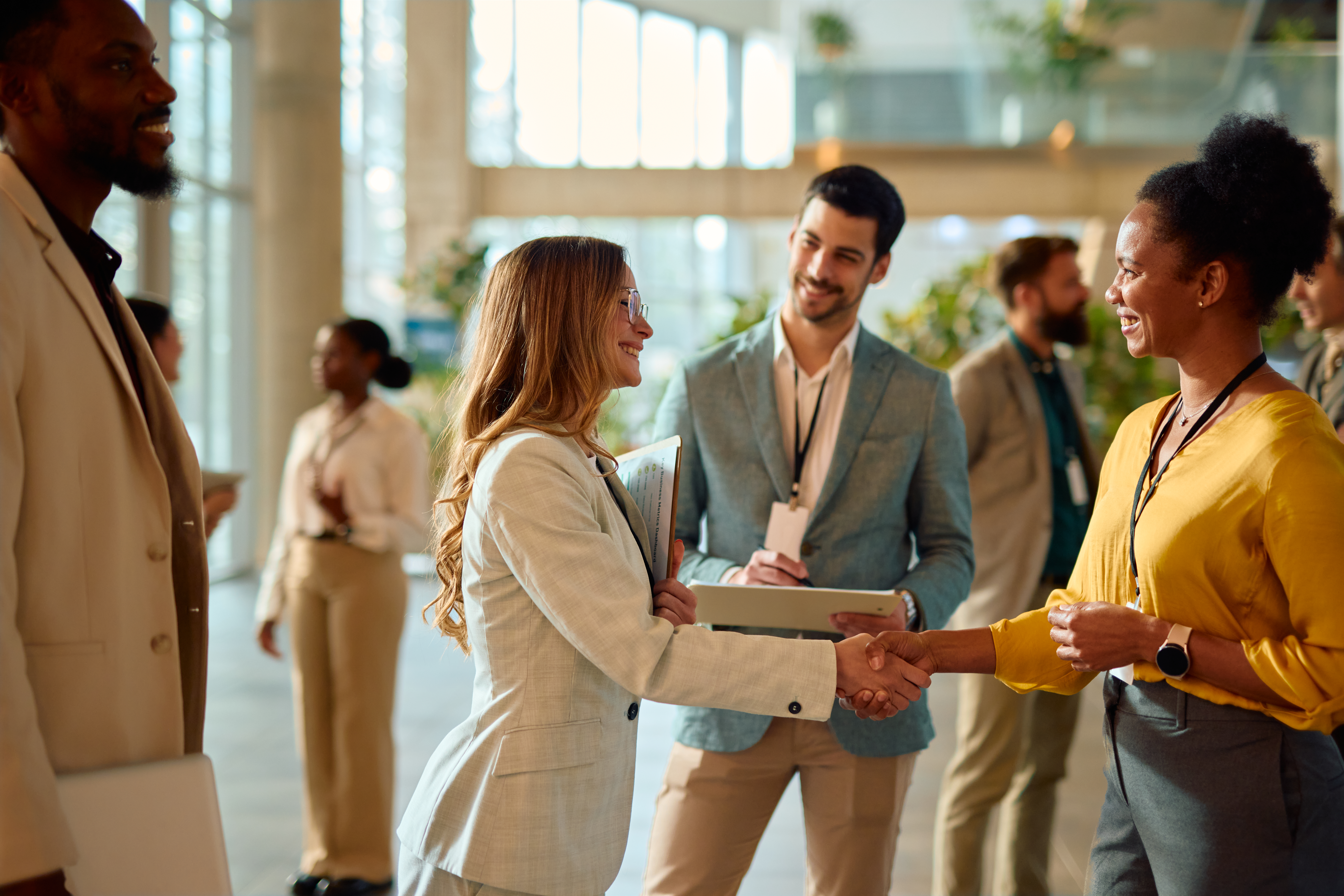 Professionals networking and shaking hands at a business event.