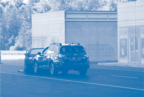 A Subaru XV applies automatic emergency braking (AEB) to stop a seminar attendee from intentionally driving into the back of a dummy, target vehicle.