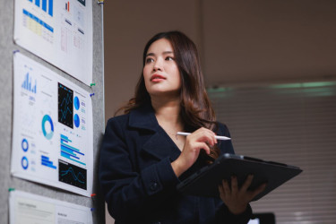 Woman holding a tablet while looking at graph data